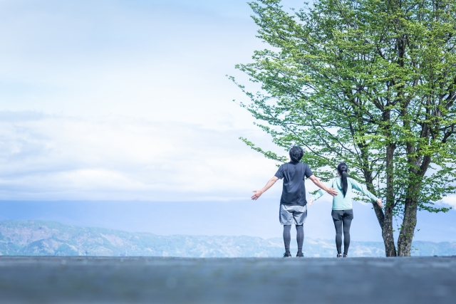自然の中で手を広げる人々